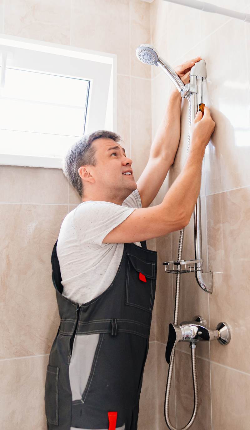 A,Master,Plumber,Installs,A,Shower,Head,In,The,Bathroom.